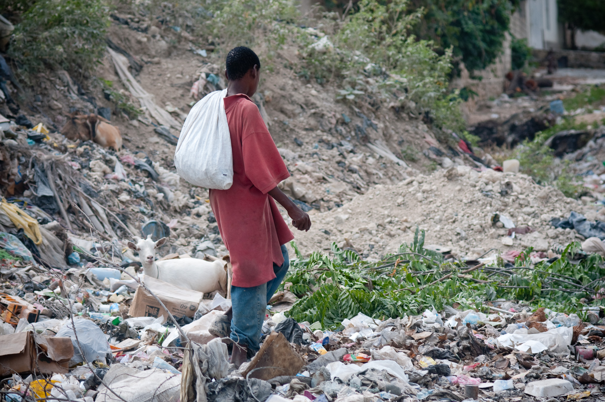 a man walks through an outdoor garbage pile