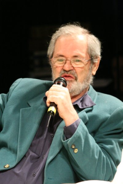 an older man holding a microphone in his hand