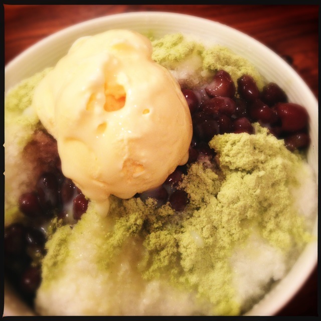 a bowl full of berries and cream on top of a wooden table