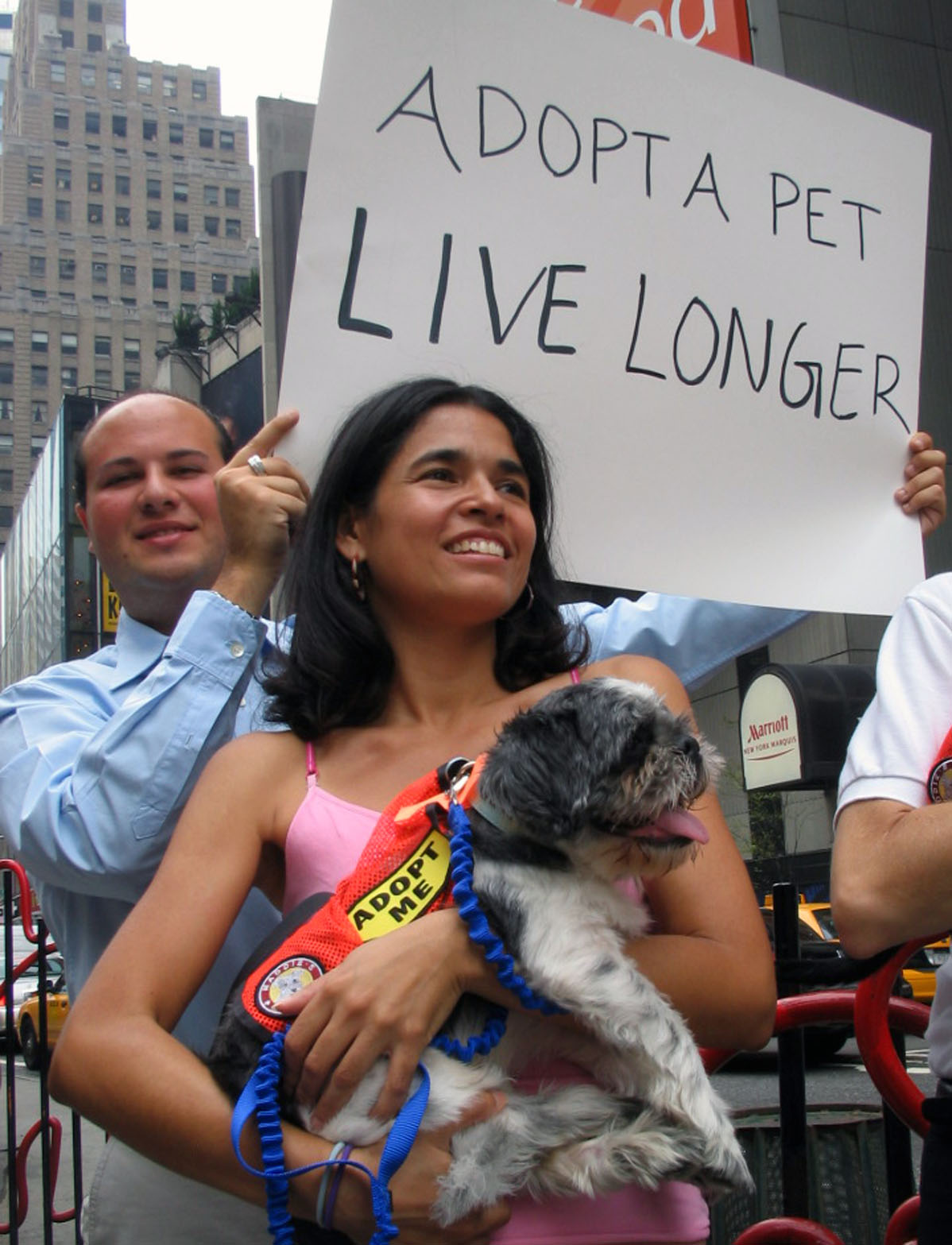 a woman holding a dog on her lap while protesting