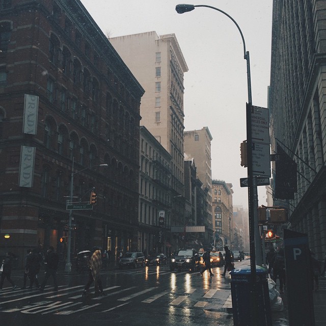 an empty city street with a traffic light on a rainy day