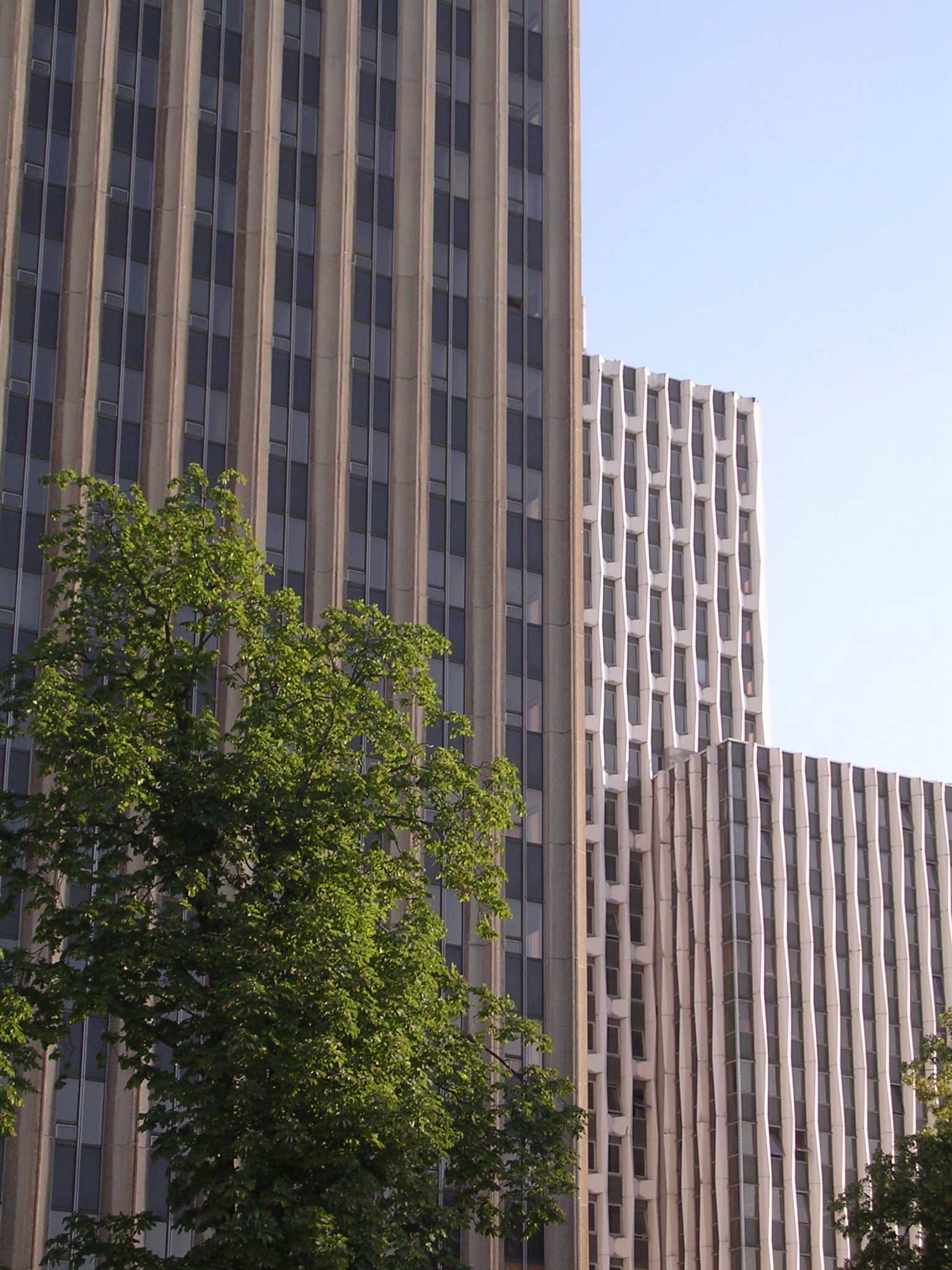 two tall buildings with different designs on the sides