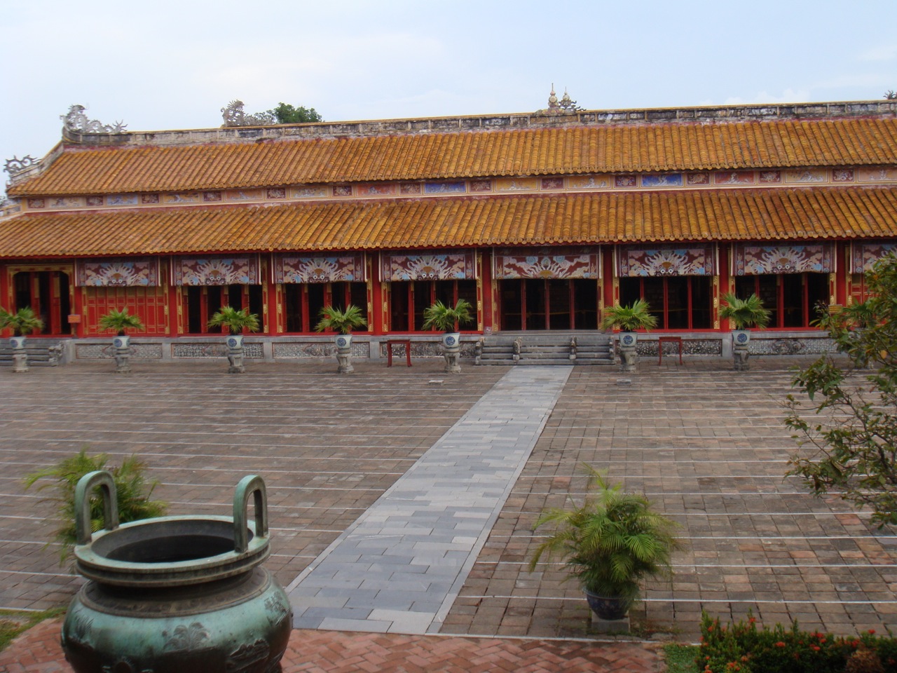 an empty courtyard with some large planters and potted trees