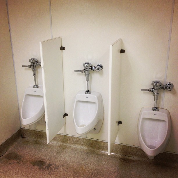 four urinals are in a room with two urinals on the walls