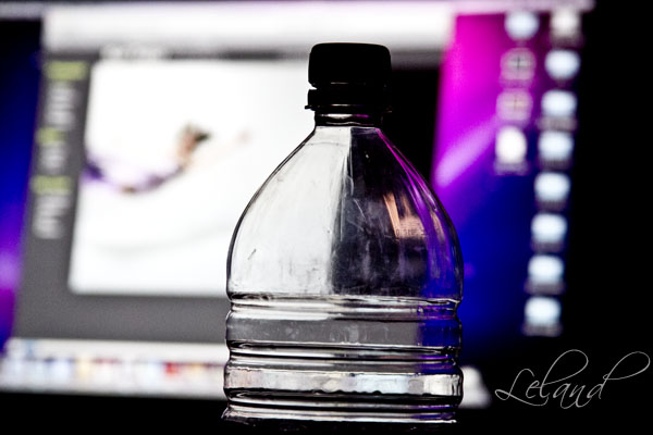 an open laptop behind a water bottle