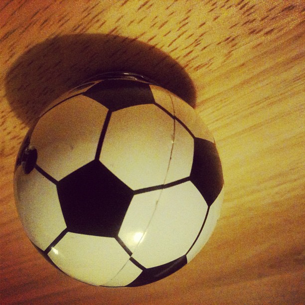 a black and white soccer ball sits on the floor