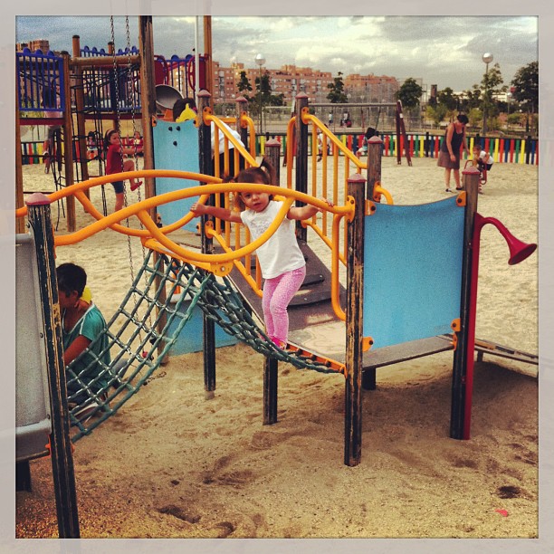 children playing at the playground with swings and climbing rails
