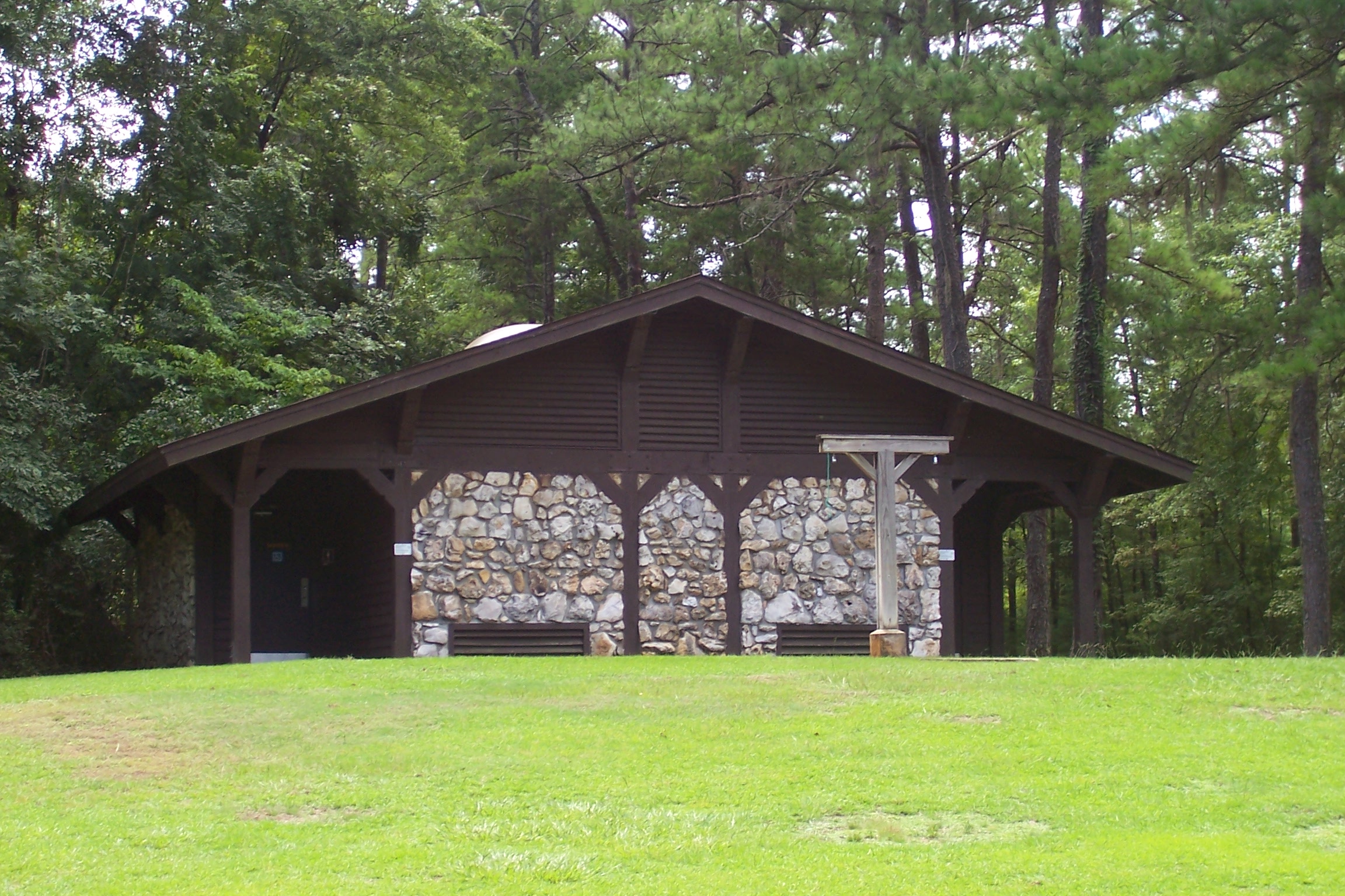 an old wooden structure is sitting in the grass