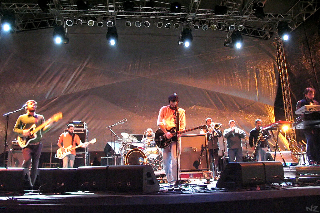 several men and women on stage with lights at a concert