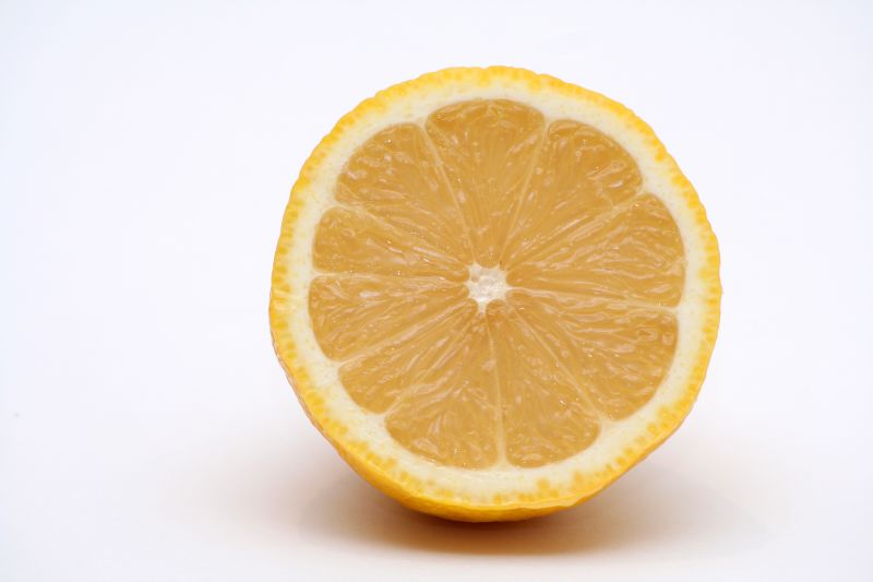 a sliced lemon is displayed on a white surface
