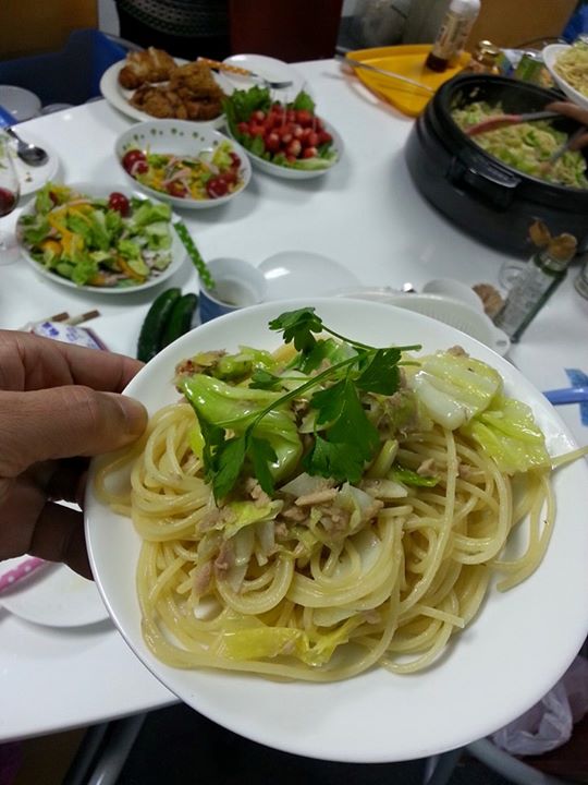 the person is holding a plate with a bunch of food