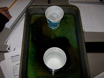 two empty cups sit on the tray of a work space