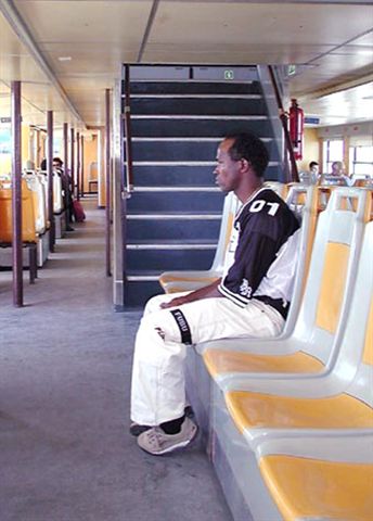 man sitting on chair in hallway at station