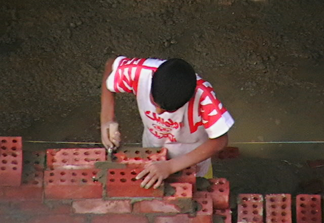 a man is working on soing out of bricks