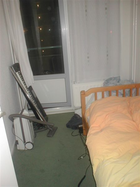 this is a bedroom with an unmade bed and a heater