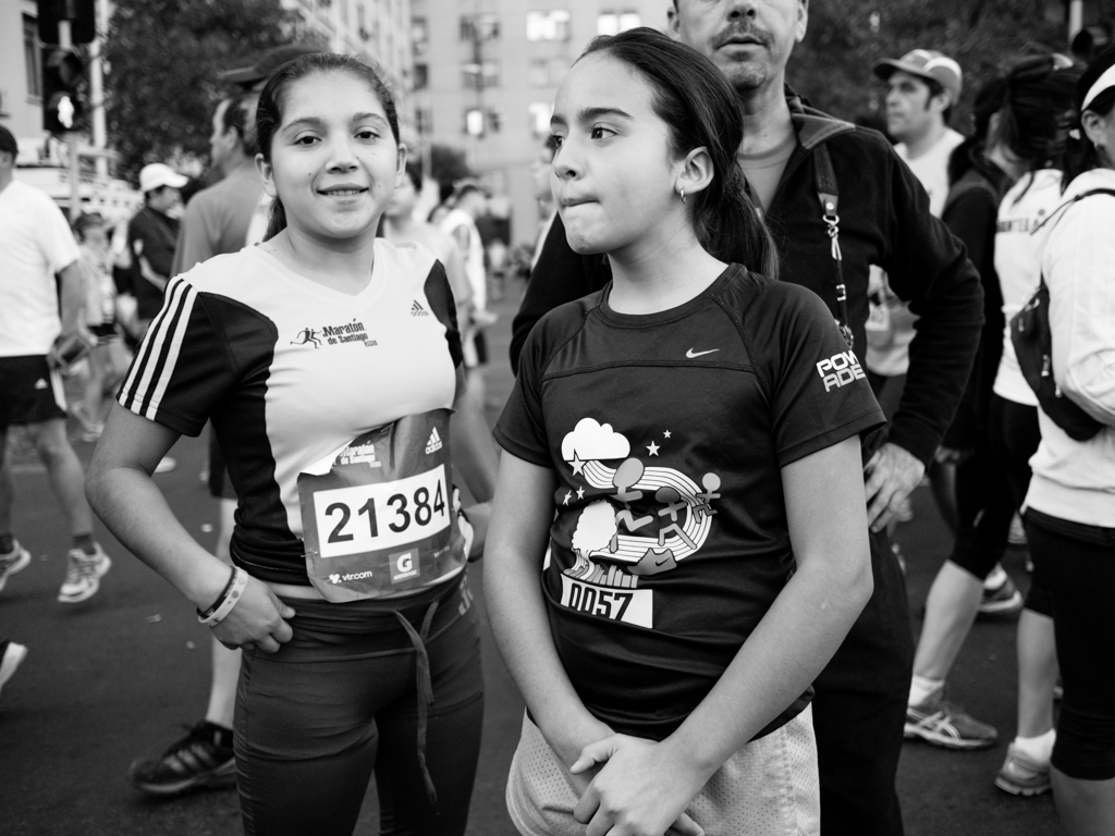 two girls standing next to each other in a group