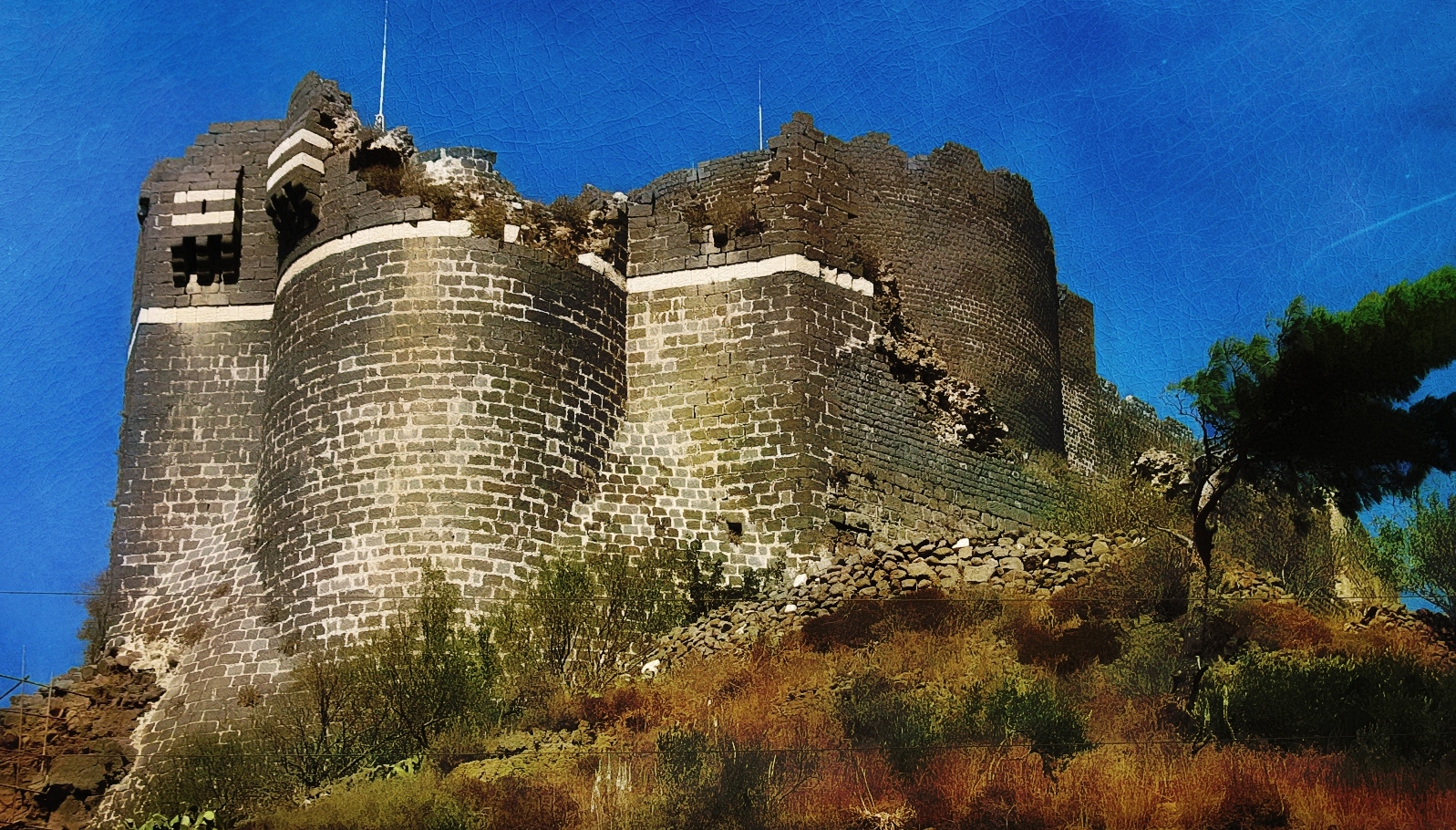 a large castle sits on a hilltop against a blue sky