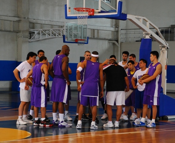 a basketball team standing in a huddle with one coach
