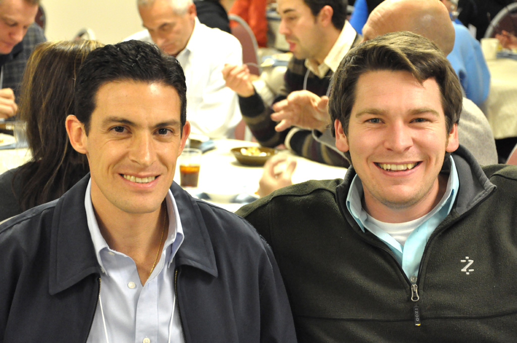 two men who are smiling while standing together