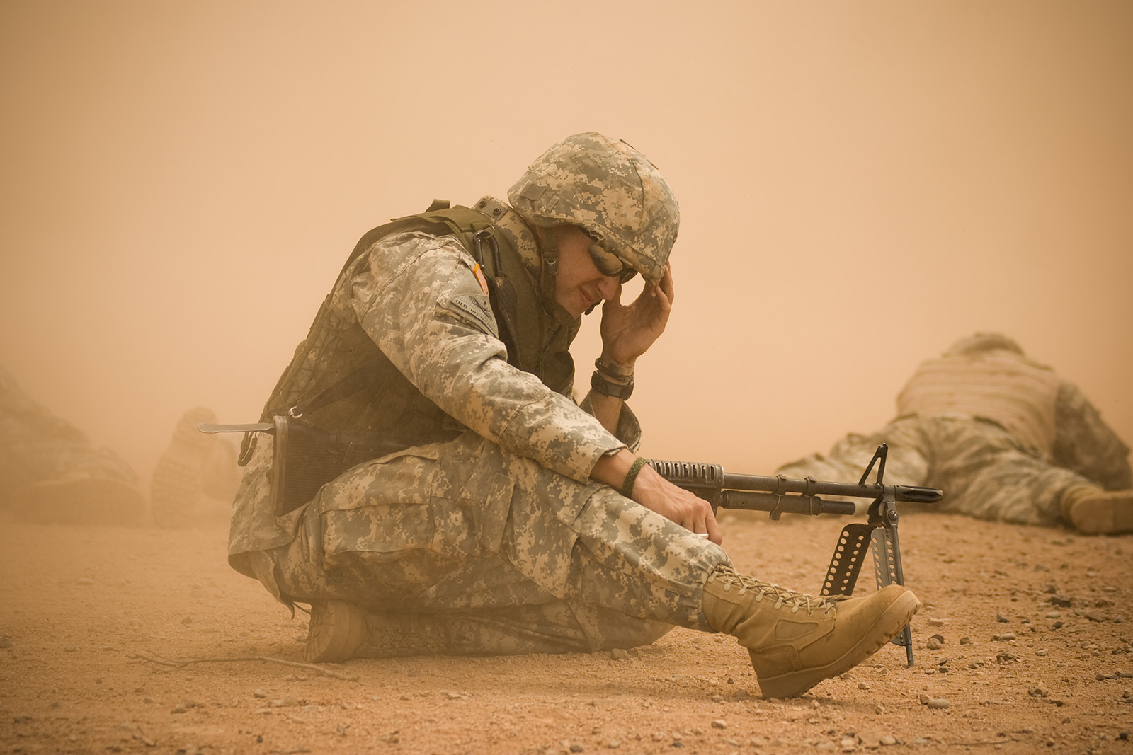 a soldier kneeling down with a machine gun