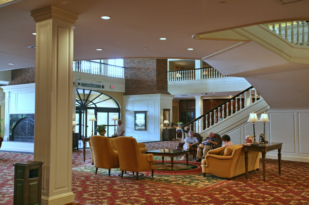 a lobby with stairs and chairs, with two men in the foreground