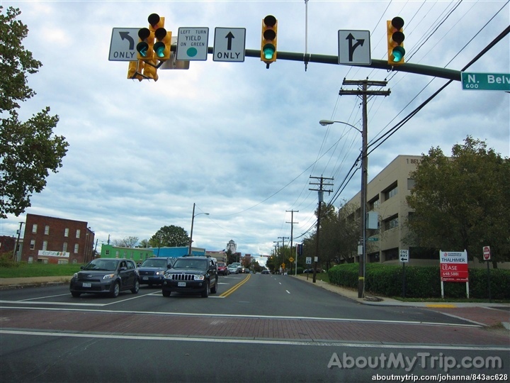 street lights are yellow as cars drive through the intersection