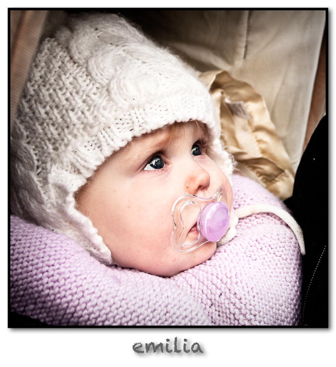a baby wearing a white bonnet and a pacifier