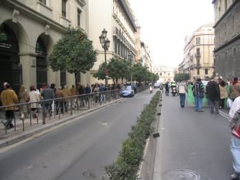 a group of people walking along a sidewalk in a city