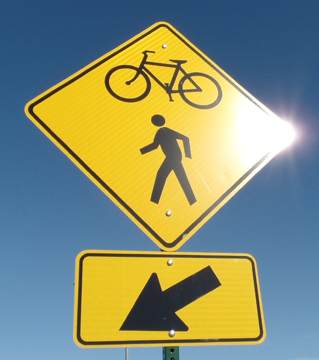 a yellow bicycle sign sitting on top of a pole