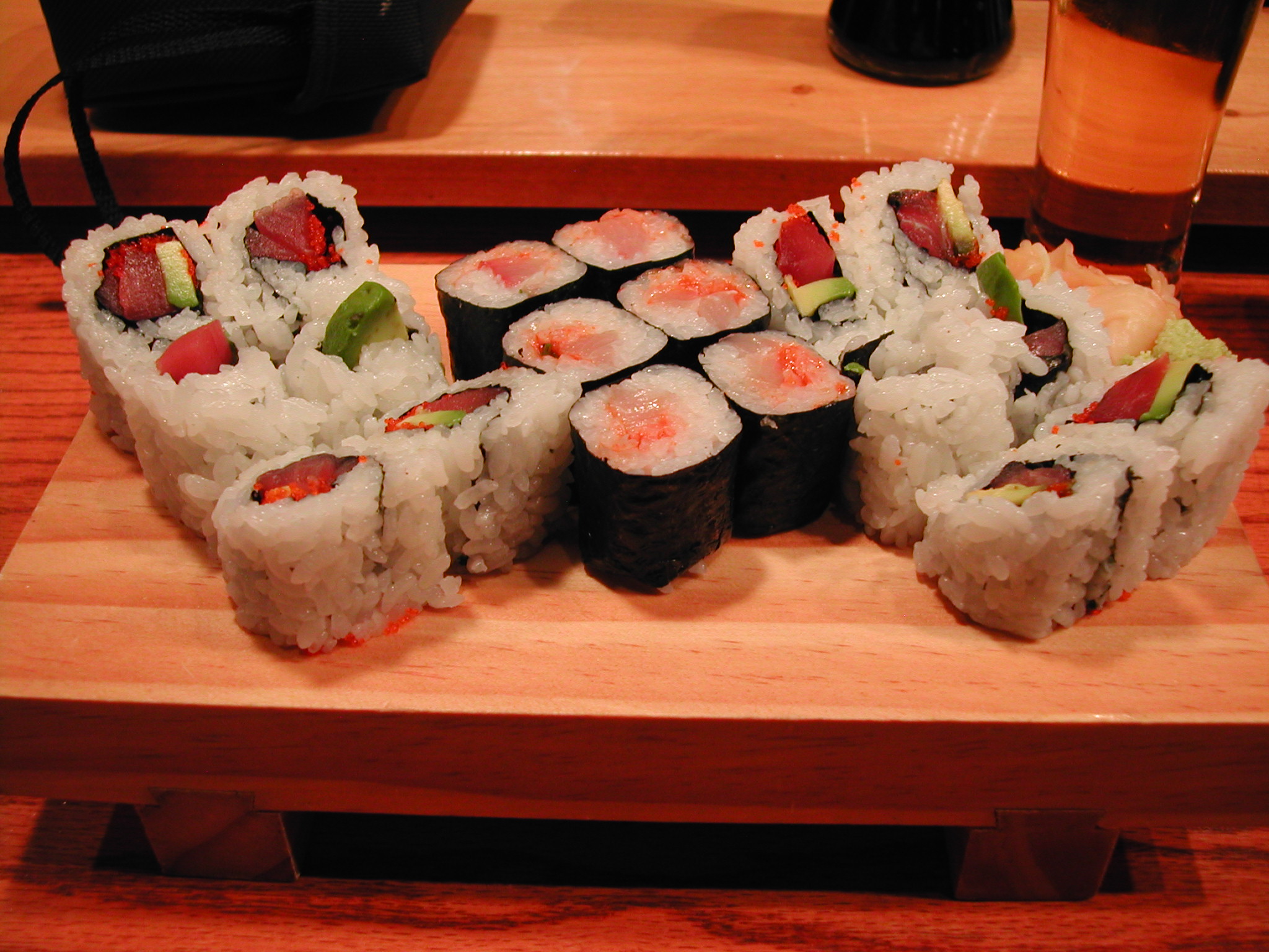 several types of sushi on a wooden surface