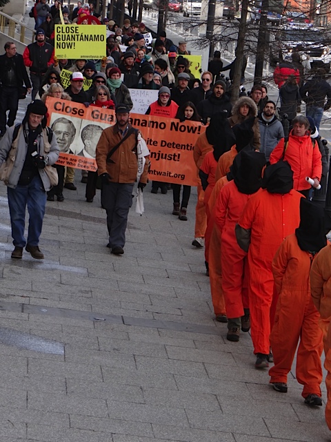 a bunch of people in orange clothes holding signs