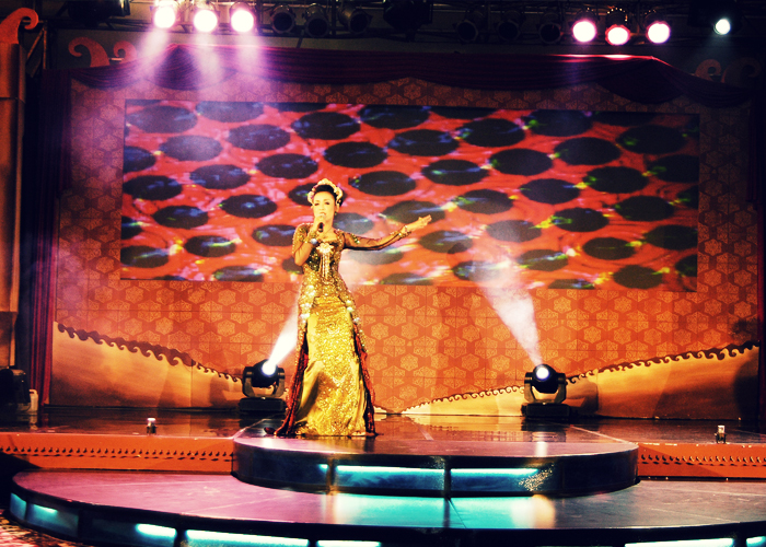 a woman standing on top of a stage with lights