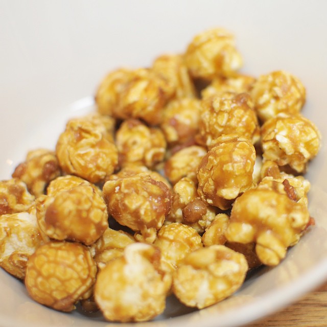 bowl full of caramel popcorn with peanuts in it