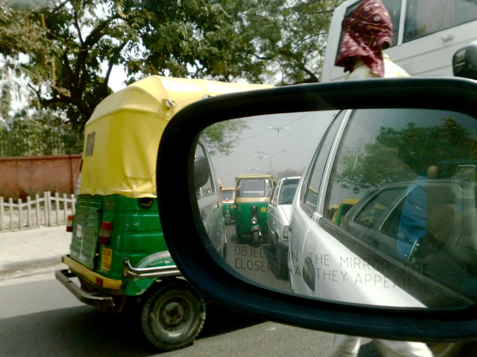 the rear view mirror is reflecting two small vehicles