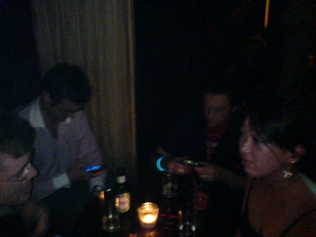 some people sitting around a table in the dark