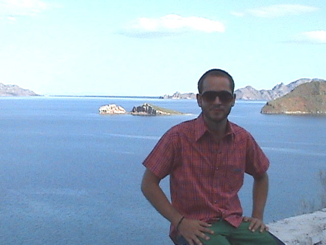 the man stands on top of a cliff overlooking the water