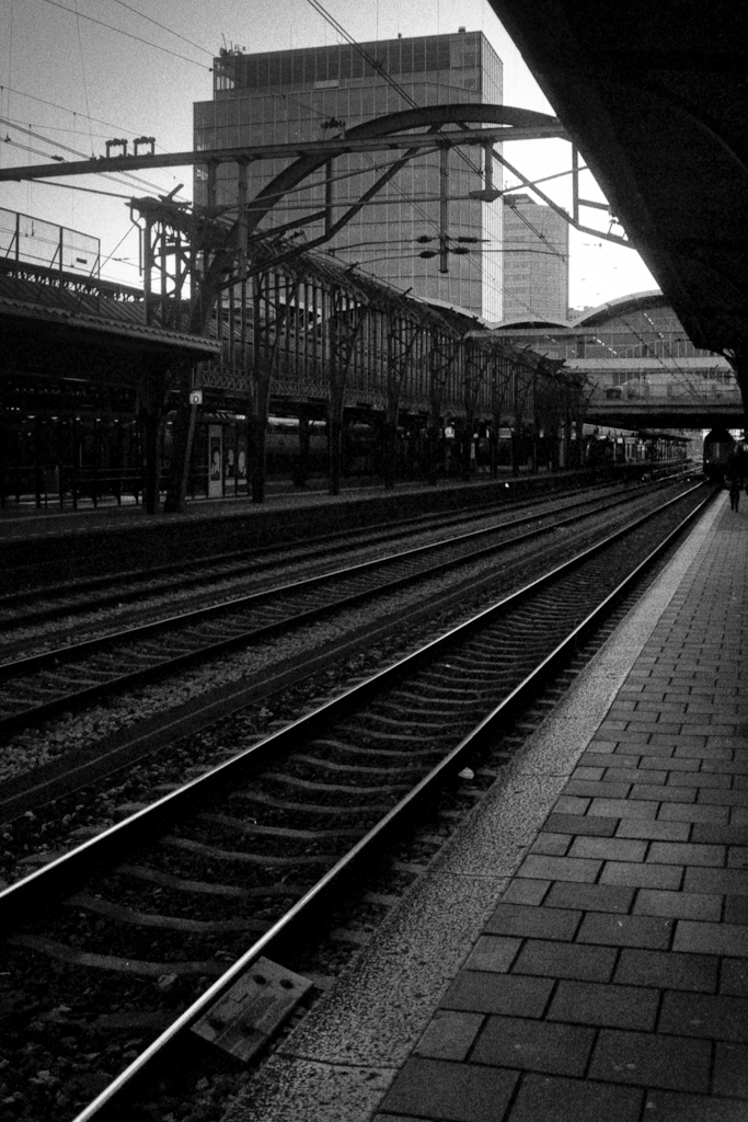 some tracks near a train station with a tall building