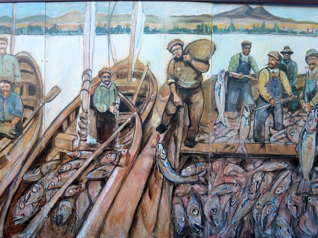 an art work with fish being laid up on the deck of a boat
