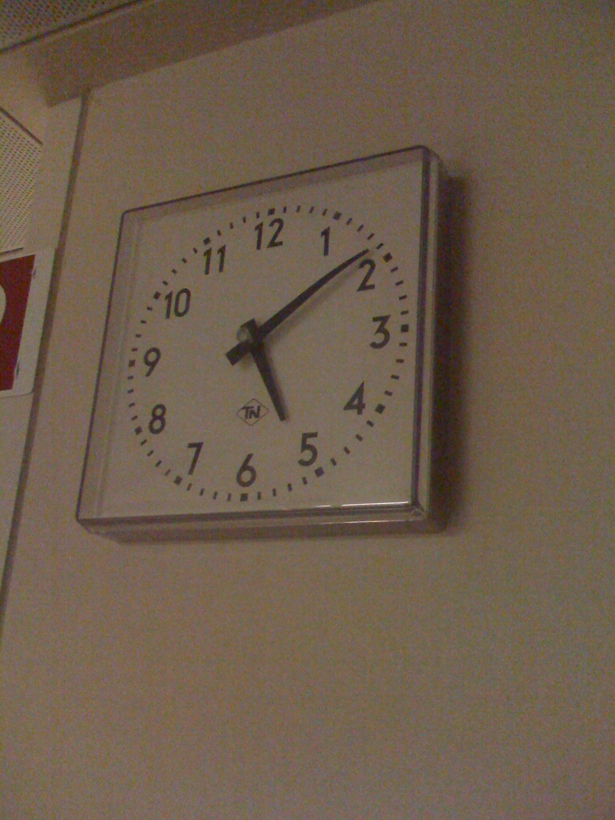 a square clock is mounted to the wall