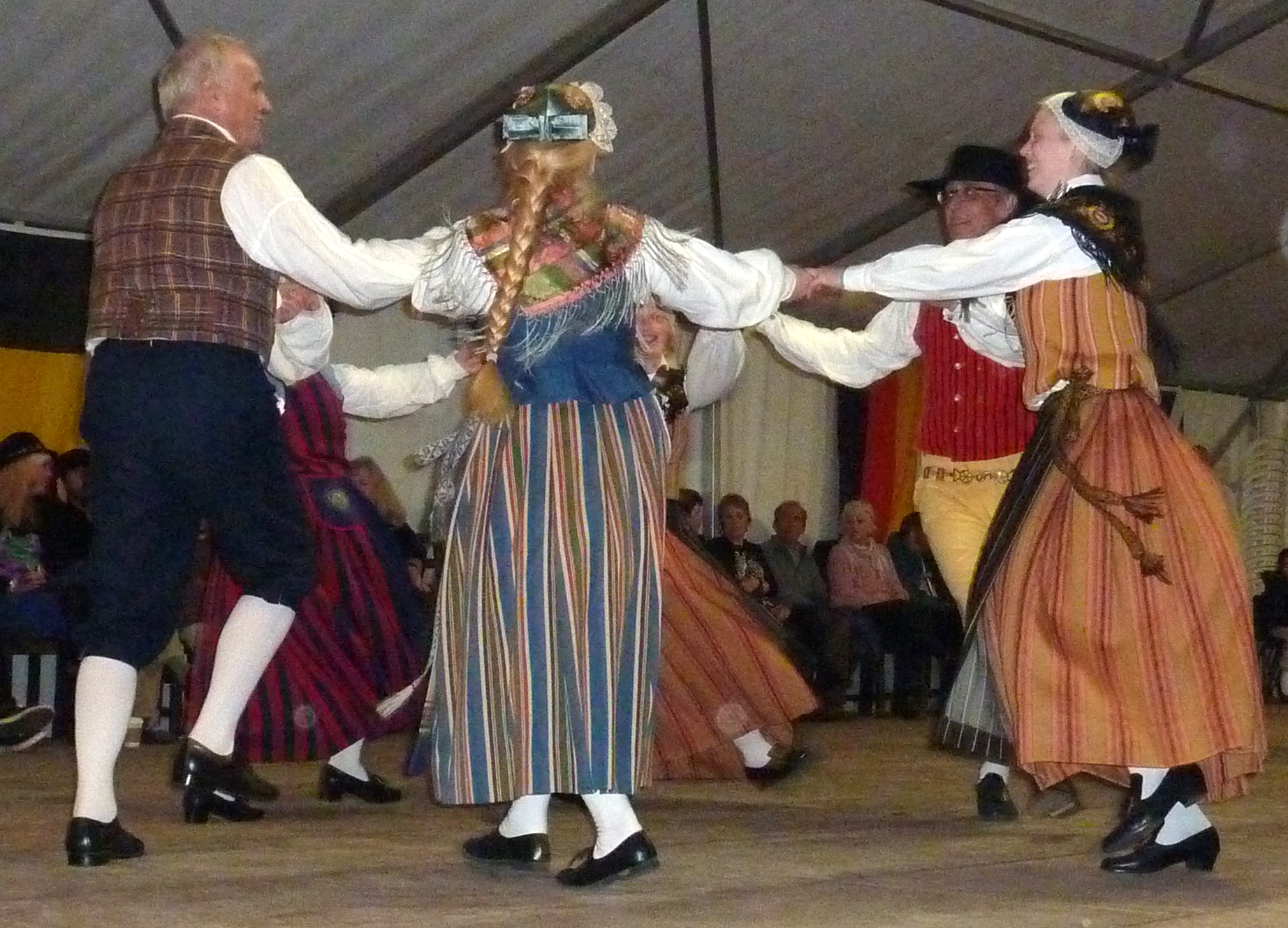 a group of people dancing around a tent