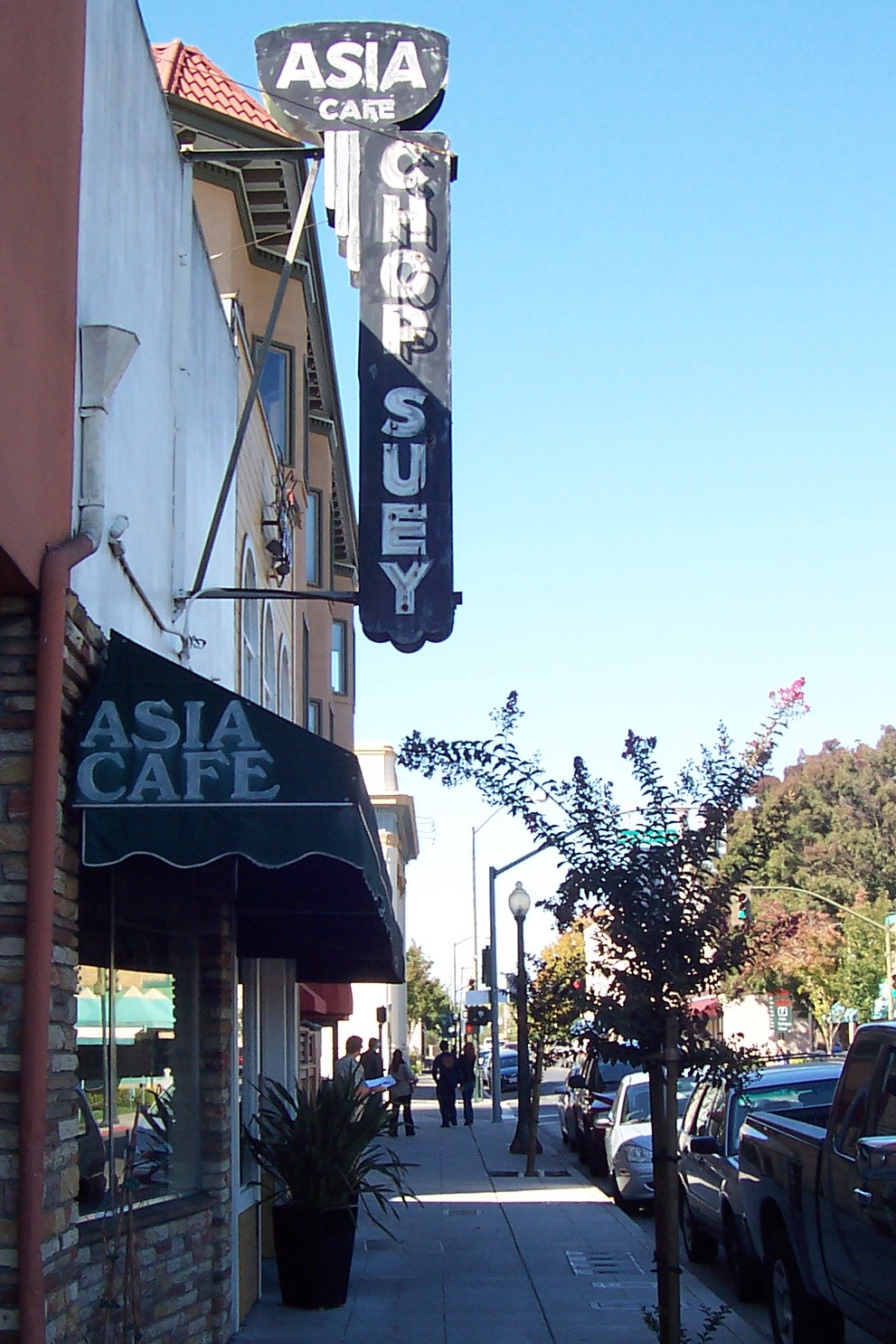 signs are hanging on the side of stores