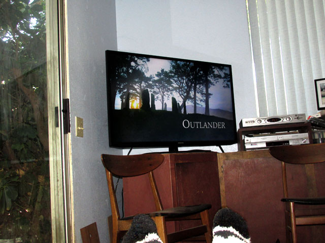 a man sits in a chair and watches the tv