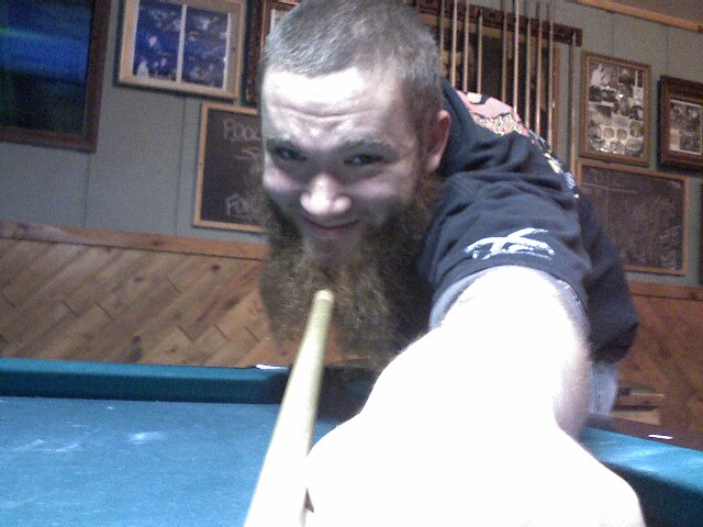 the man is playing pool at the table