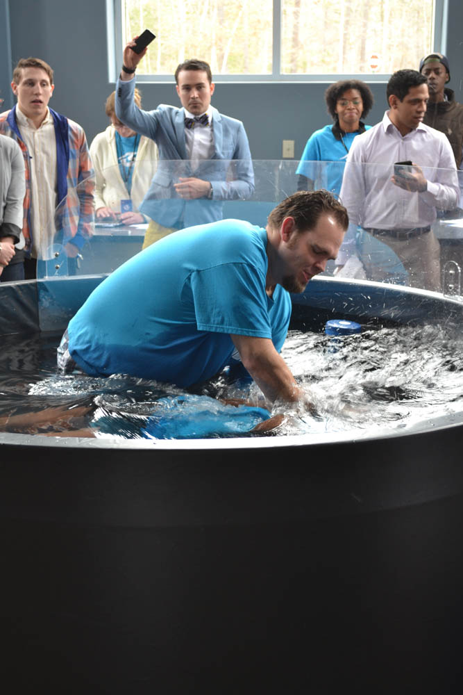 a man in blue shirt taking a drink in an air bath