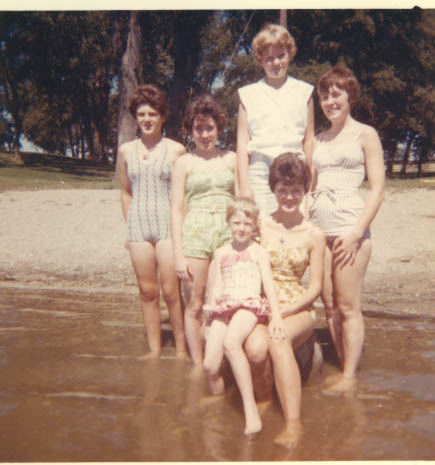 a group of women standing next to each other in the water
