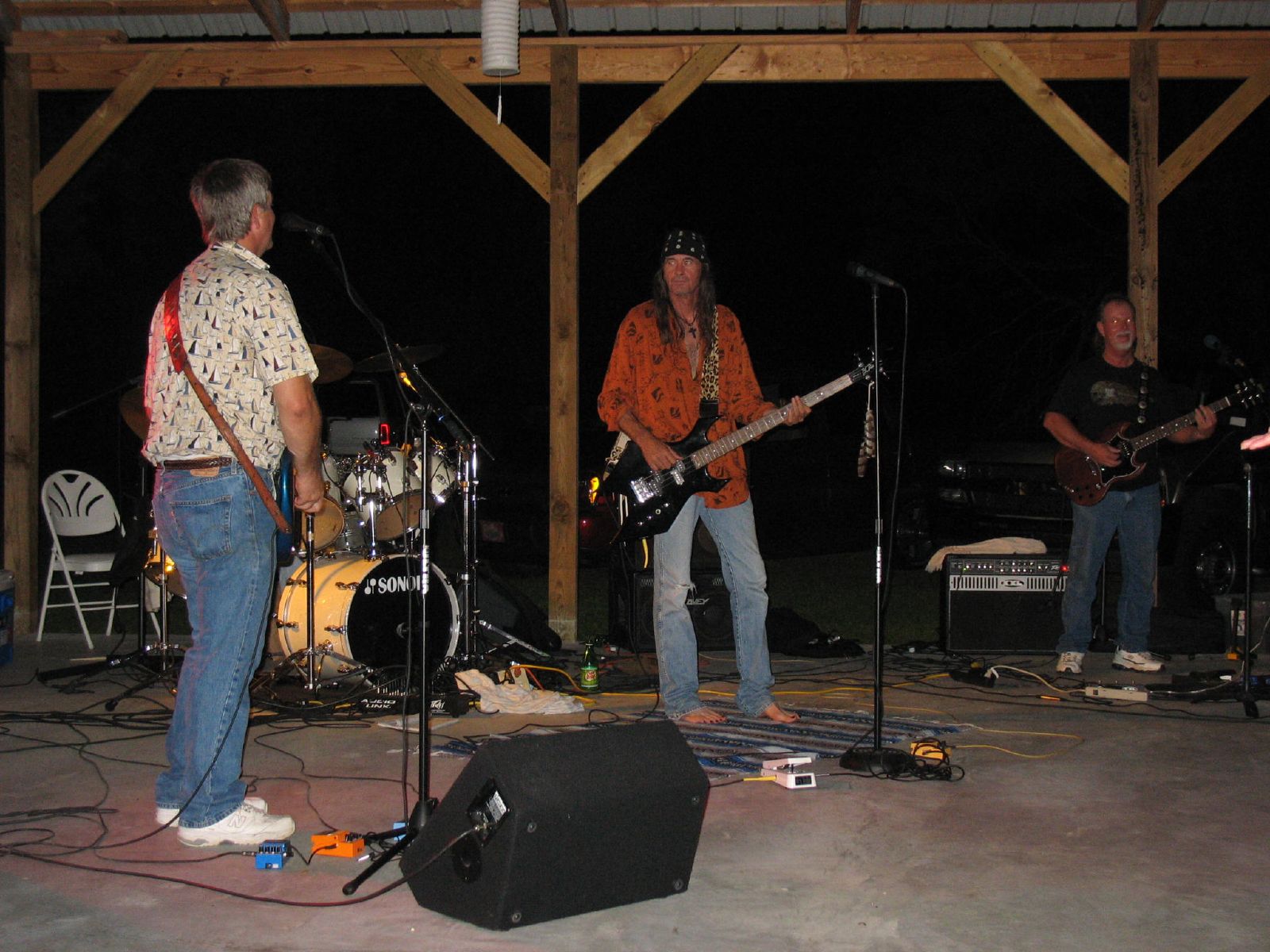 three men and one man singing and playing guitars