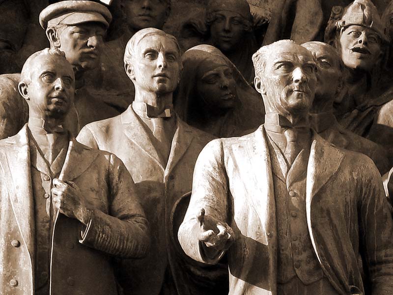 a group of stone statues with men in hats