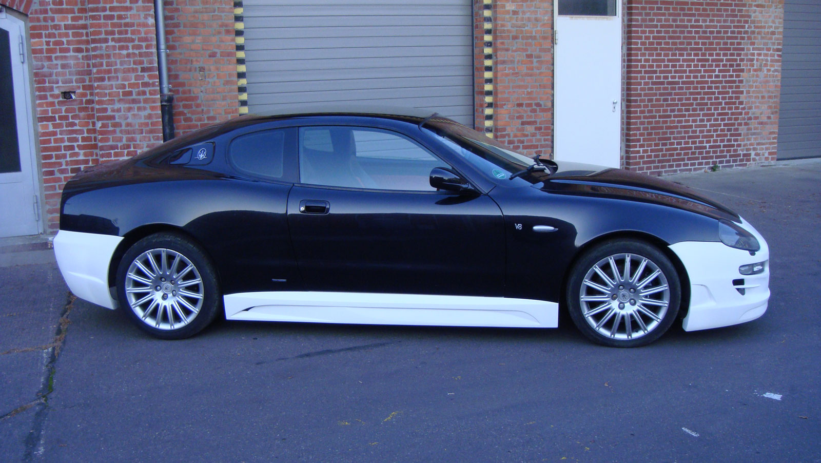 a black and white car parked in front of a garage