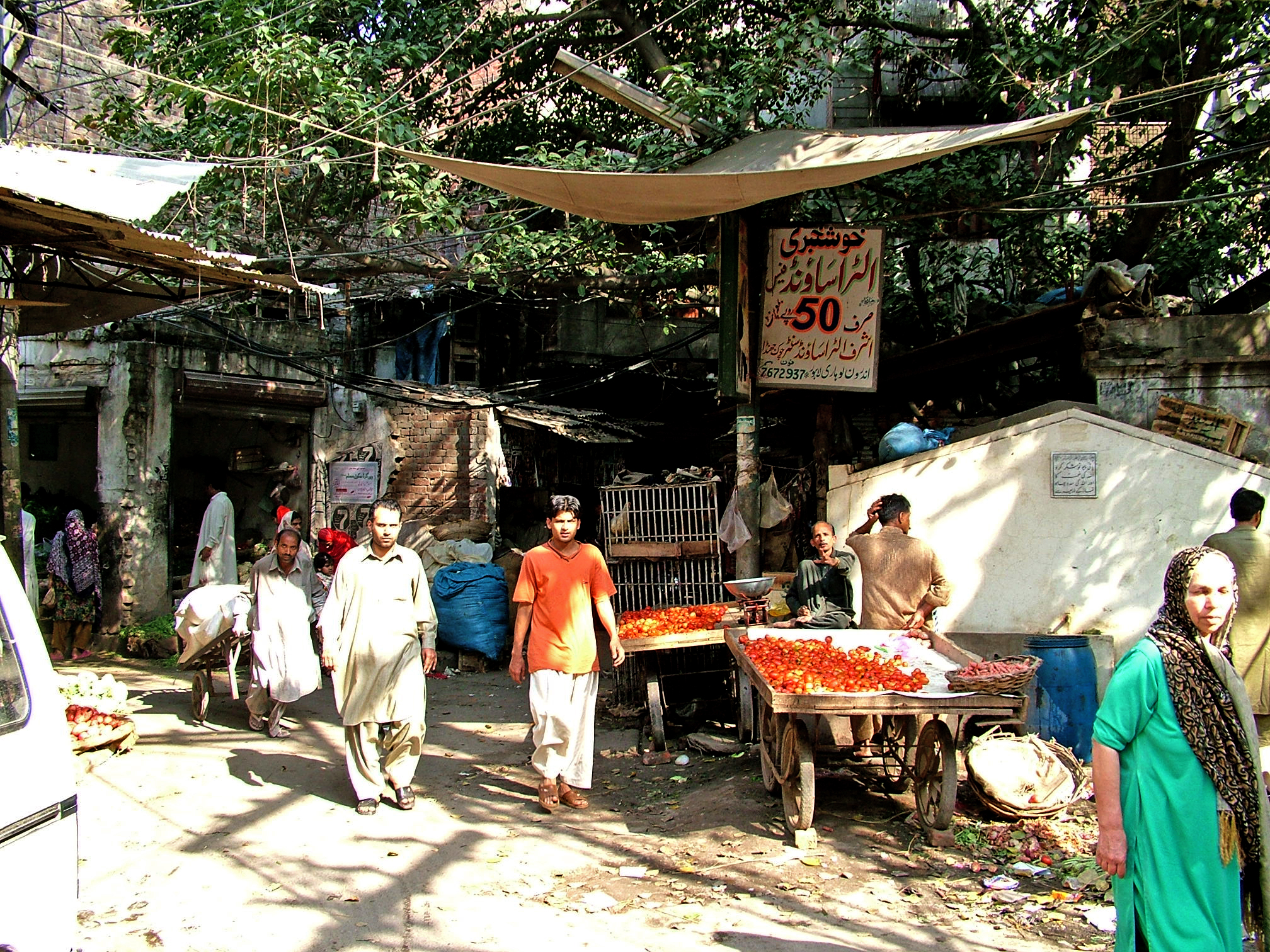 several men walking around an outdoor market selling items