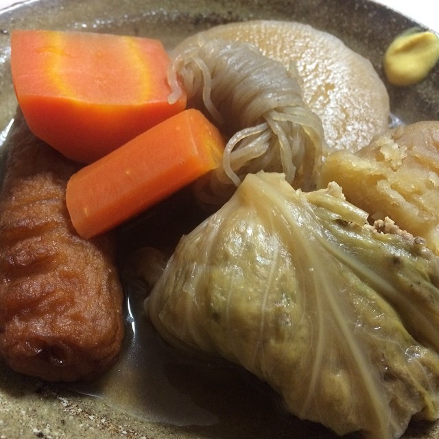 a metal dish with a spoon full of meat and vegetables